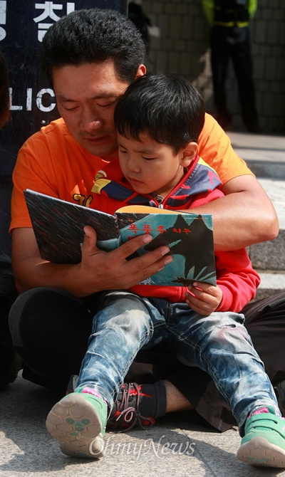  김정회 위원장이 아들에게 동화책을 읽어주고 있다.