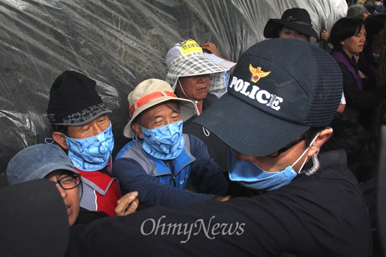  2일 대규모 공권력이 투입된 속에 한국전력공사가 송전탑 공사를 재개한 가운데, 밀양시는 단장면 단장리 소재 '765kv 신고리-북경남 송전선로 4공구 건설공사 자재 적치장' 건너편에 있는 움막을 철거하기 위해 행정대집행에 나섰다. 사진은 경찰에 밀린 주민들이 움막 쪽에 몰려 대처하고 있는 모습.