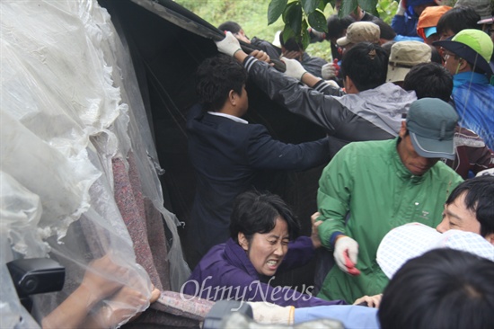  2일 대규모 공권력이 투입된 속에 한국전력공사가 송전탑 공사를 재개한 가운데, 밀양시는 단장면 단장리 소재 '765kv 신고리-북경남 송전선로 4공구 건설공사 자재 적치장' 건너편에 있는 움막을 철거하기 위해 행정대집행에 나섰다. 사진은 밀양시청 공무원들이 움막의 일부 시설물을 뜯어내고 있는 모습.