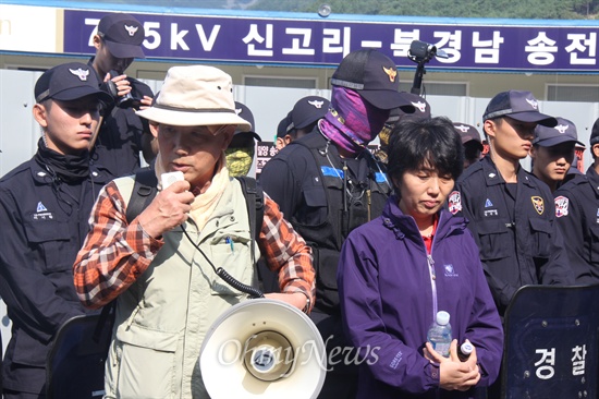 한국전력공사가 2일에 이어 3일에도 밀양 송전탑 공사를 계속하고 있는 가운데, 교사 출신으로 밀양시 산외면 보라마을에 사는 김기업(68)씨가 단장면 단장리 소재 '공사장비 적치장' 앞에서 제자인 문정선 밀양시의원과 함께 서서 공사 반대를 외치고 있다.