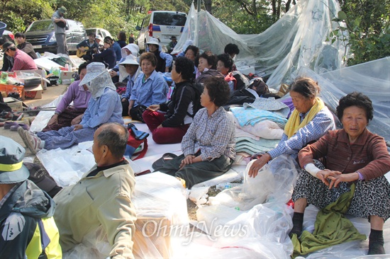 밀양시 상동면 여수마을 주민 30여명은 1일부터 126번 철탑 현장 아래에서 '송전탑 공사 중단'을 요구하며 밤샘 농성하고 있다. 사진은 3일 오후 주민들이 앉아 있는 모습.