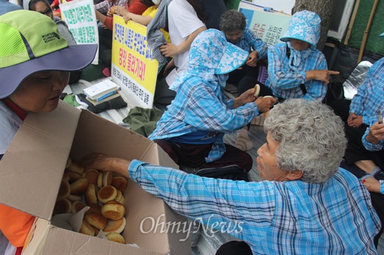  한국전력공사가 밀양 송전탑 공사를 재개한지 엿새째인 7일 낮 12시경 주민들이 밀양시 단장면 단장리 소재 '송전선로 공사장비 적치장' 앞에서 식사 대용으로 빵을 나눠 먹고 있다.