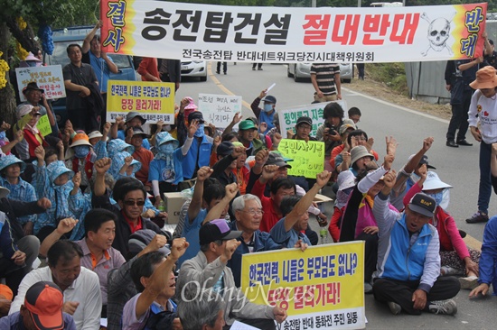  한국전력공사가 밀양 송전탑 공사를 재개한지 엿새째인 7일 낮 12시경 주민들이 밀양시 단장면 단장리 소재 '송전선로 공사장비 적치장' 앞에서 농성하면서 공사 중단을 요구하며 구호를 외치고 있다.