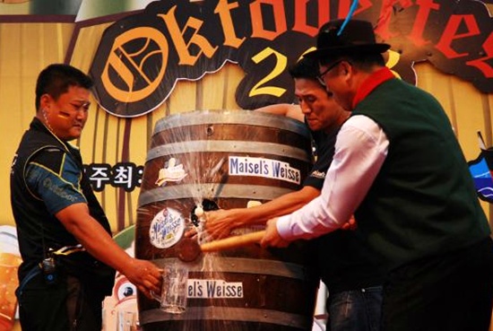 독일마을 대표와 정현태 남해군수 등이 독일 전통 맥주가 담긴 오크통을 열고 있습니다.