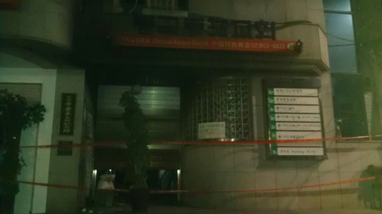 통제선이 설리된 건물 외벽에 화재로 인한 안내문이 적혀 있다. 