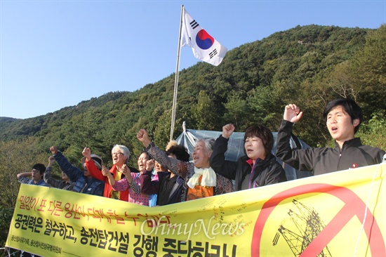  용산참사진상규명위원회 소속 전재숙, 유영숙씨 등이 12일 오후 밀양시 부북면 위양리 주민들이 송전탑 반대 투쟁을 벌이고 있는 농성 현장을 찾아 격려했다. 사진은 127번 철탑 현장에 있는 움막농성장 앞에서 주민들과 함께 펼침막을 들고 구호를 외치는 모습.