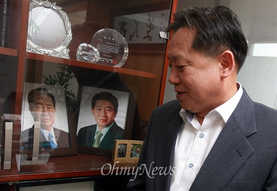 집무실 책장에 있는 고 김대중, 노무현 전 대통의 사진을 보는 차성수 구청장.