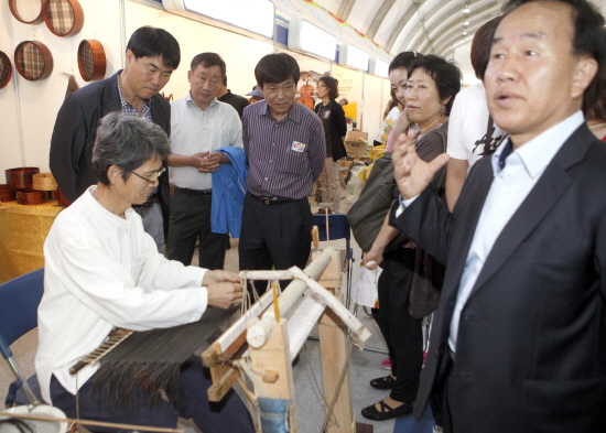 마미체 명장 백경현 작가가 소나무판으로 만든 전통 도구로 마미체 짜는 모습을 시연하고 있다. 