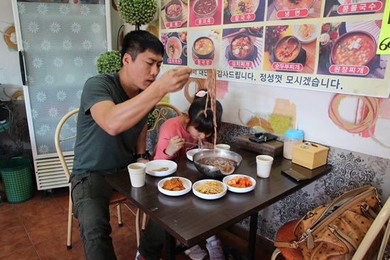  은별이가 아빠와 함께 팥죽(팥칼국수)을 맛있게 먹는다.
