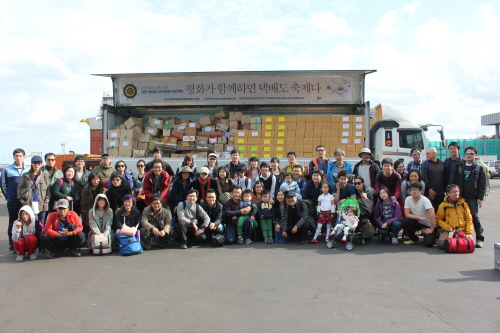 18일 제주항에 도착한 '강정 책마을 십만대권 프로젝트' 참가자들이 3만 5,000여권의 책과 함께 기념사진을 찍었다.