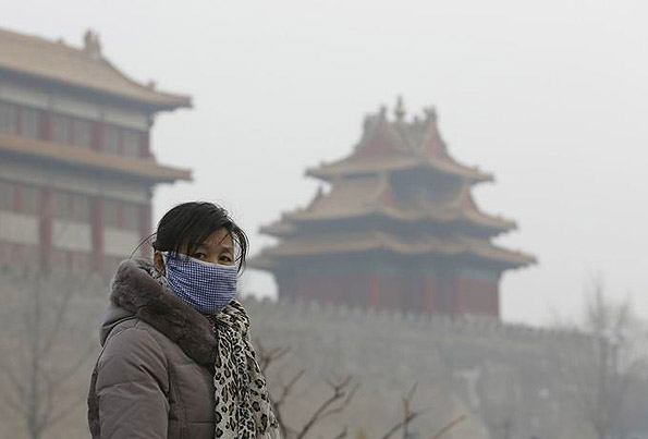 대기오염에 인해 스모그로 뒤덥힌 베이징 자금성 앞에 한 베이징 시민이 마스크를 쓴 채로 서 있다. 