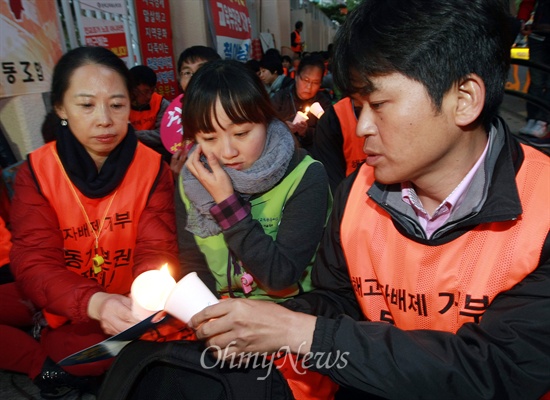 촛불집회에 참석한 전교조 조합원들이 서로의 촛에 불을 붙이고 있다.