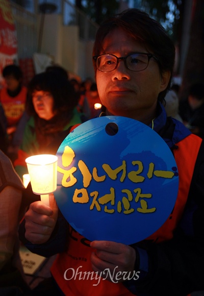 한 전교조 조합원이 '힘내라 전교조'가 적힌 피켓과 촛불을 들고 있다.