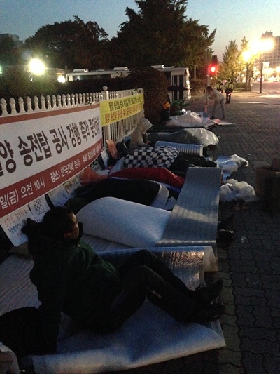 지난 24일 밤 국회 정문 앞 도로에 누워 '송전탑 건설 반대' 철야노숙농성을 하고 있는 밀양 대책위와 주민 20여명의 모습. 
