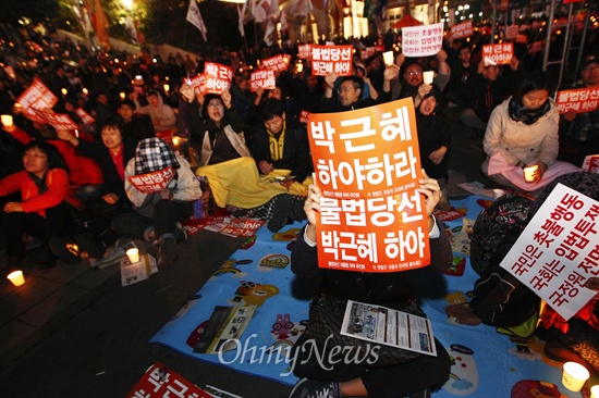 26일 오후 서울 용산구 서울역 앞에서 국정원 선거개입과 노동탄압을 규탄하는 촛불 집회에 참석한 시민들이 '박근혜 하야하라'고 적힌 피켓을 들고 구호를 외치고 있다. 
