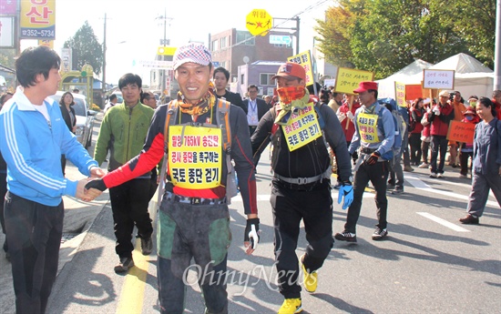  28일 밀양시 상동면 금호마을 박정규 이장과 주민 박문일, 정태호씨가 밀양 송전탑 공사 중단을 요구하며 28일부터 2주 동안 전국 국토대장정에 나서면서 상동역 앞을 출발하자 주민들이 나와 격려하고 있다.