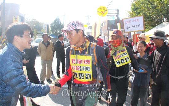  28일 밀양시 상동면 금호마을 박정규 이장과 주민 박문일, 정태호씨가 밀양 송전탑 공사 중단을 요구하며 28일부터 2주 동안 전국 국토대장정에 나서면서 상동역 앞을 출발하자 주민들이 나와 격려하고 있다. 사진은 박정규 이장과 이계삼 사무국장이 악수하는 모습.