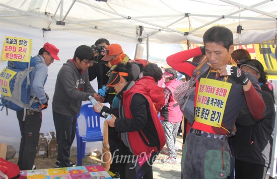  28일 밀양시 상동면 금호마을 박정규 이장과 주민 박문일, 정태호씨가 밀양 송전탑 공사 중단을 요구하며 28일부터 2주 동안 전국 국토대장정에 나서면서 상동역 앞에 있는 천막 농성장에서 깃발을 꽂는 등 채비를 하고 있다.