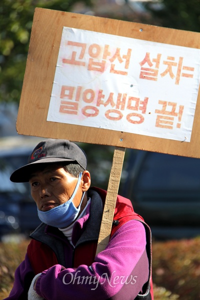  밀양시 상동면 금호마을 박정규 이장과 주민 박문일, 정태호씨가 10월 28일 오전 상동역 앞에서 기자회견을 열고 2주 동안 밀양 송전탑 공사 중단을 요구하는 국토대장정에 나선 가운데, 한 주민이 이들을 격려하기 위해 피켓을 들고 참석했다.