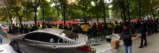 사측의 노조 천막농성장 기습 철거에 반대하며 본사 앞에서 집회를 열고 있는 골든브릿지 노조원들을 출동한 경찰 30여 명이 둘러싸고 있다. 