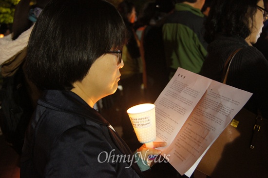 전교조 대구지부가 30일 오후 7시부터 대구시교육청 앞에서 '참교육 실천, 민주주의 수호' 결의대회를 개최한 가운데 한 교사가 촛불을 들고 결의문을 읽고 있다. 