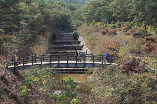 여행객들이 섬진강 둘레길을 따라 걷고 있다. 증기기관열차가 다니는 철길에서 본 섬진강 둘레길 모습이다.
