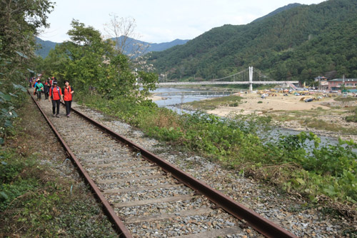 철길 위를 걷고 있는 여행객들. 섬진강 둘레길은 가정마을을 지나면서 폐선이 된 철길 위를 걷게 된다.