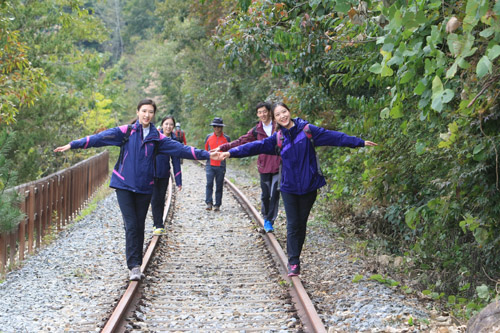 철로의 레일 위를 걷고 있는 여행객들. 섬진강 둘레길에서 맛볼 수 있는 특별한 즐거움이다.