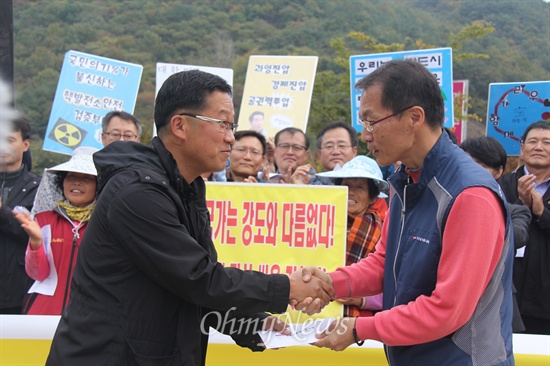  전국공무원노동조합 김중남 위원장은 전국 각 지부장들과 함께 31일 오후 밀양시 단장면 바드리마을 입구에서 기자회견을 열어 밀양 송전탑 공사 중단을 촉구했다. 사진은 김중남 위원장이 밀양765kV송전탑반대대책위 공동대표인 김준한 신부한테 성금을 전달하는 모습.