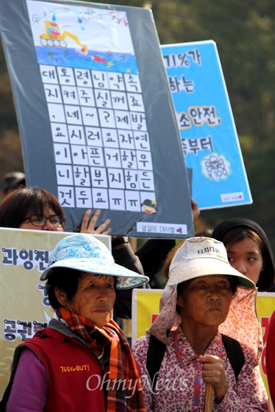  밀양 송전탑 공사와 관련한 갈등이 계속되고 있는 속에, 주민들은 공사차량으리 출입을 막기 위해 밀양시 단장면 바드리마을 입구 옆에 있는 대추밭에서 비닐을 설치해 놓고 농성하며 피켓을 들고 서 있다.