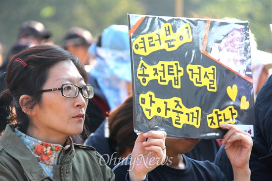  밀양 송전탑 공사와 관련한 갈등이 계속되고 있는 속에, 10월 31일 밀양시 단장면 바드리마을 입구에서 열린 기자회견에 참석한 사람들이 피켓을 들고 서 있다.