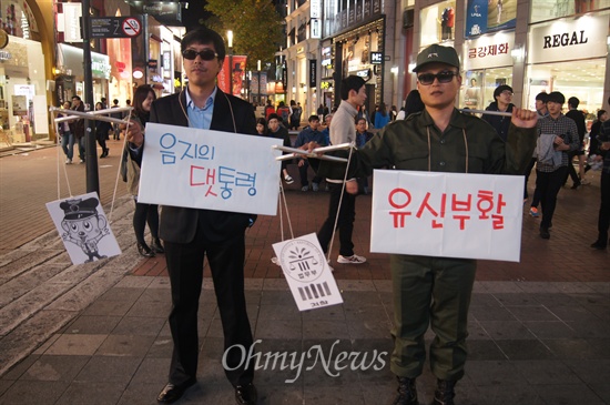  국가기관의 불법 대선개입을 규탄하는 18차 시국대회가 대구백화점 앞에서 열렸다. 박근혜 대통령의 유신회귀를 풍자하는 퍼포먼스를 벌이고 있다.