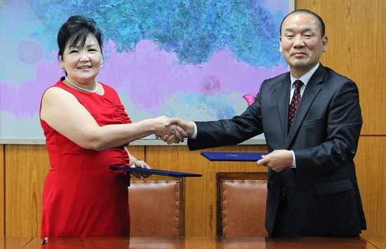  마산 창신고와 몽골 3개 학교가 자매결연을 맺었다. 사진은 몽골 '다와후' 여교장과 창신고 장대성 교장이 협약서를 주고받는 모습.