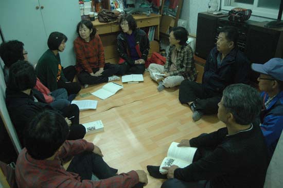 김현식 선생이 사과밭의 농막으로 쓰고 있는 컨테이너에서 독서 모임을 갖고 있는 교사들.