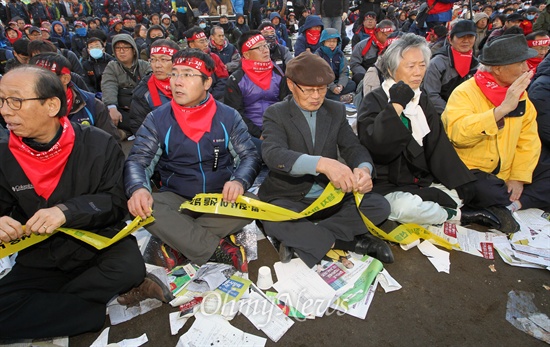 10일 오후 서울광장에서 열린 전국노동자대회에서 신승철 민주노총 위원장 등 참가자들이 '법·질서, 이 선을 넘지 마시오'라고 쓰인 폴리스라인을 찢어버리고 있다.