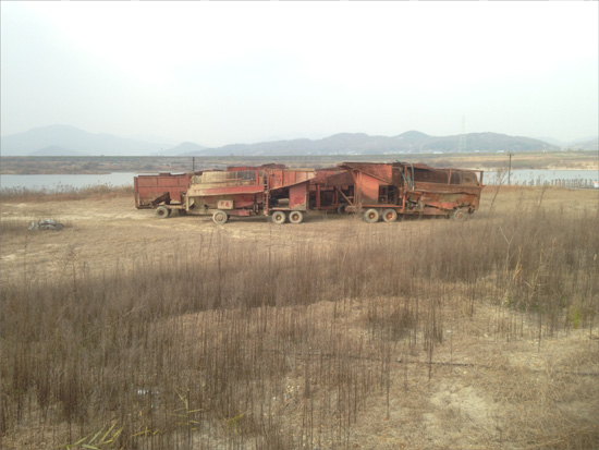 금강 백제보 인근 하천둔치에 공사를 마친 녹슨장비들이 방치되어 있다.