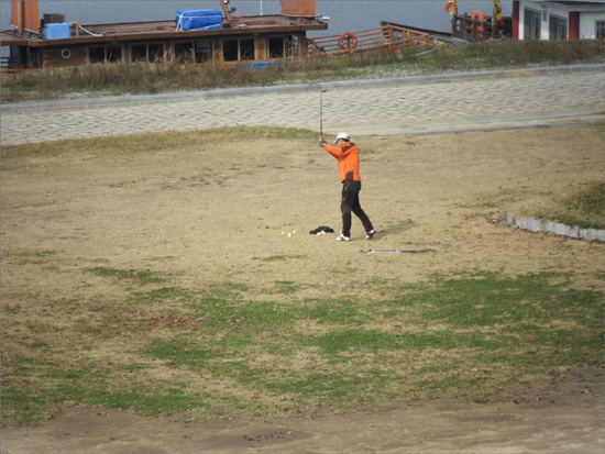 부여군 구드레나루 인근 금강변에서 골프연습을 하고 있는 한 남성. 부여군이 '골프연습금지'라는 현수막을 설치해 놨지만 아랑곳하지 않고 연신 골프공을 날리고 있다. 