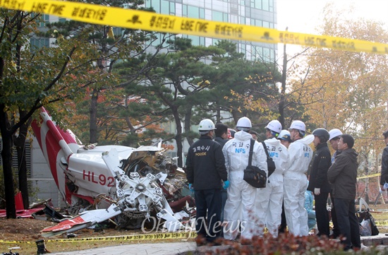 엘지전자 소속의 헬기가 충돌한 16일 오전 서울 강남구 아이파크 아파트 현장에서 국립과학수사연구원과 소방대원들이 추락한 헬기 잔해를 조사하고 있다.