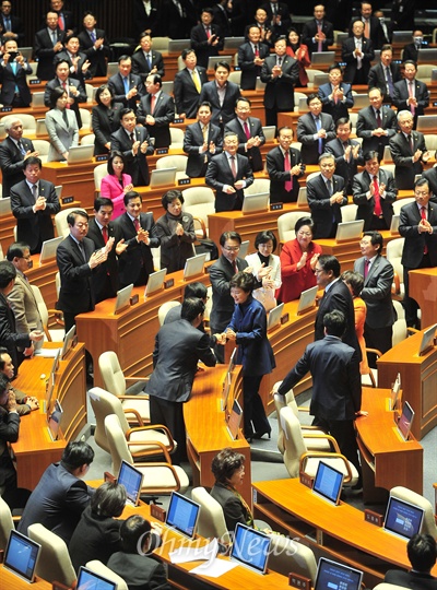 박근혜 대통령이 18일 오전 국회에서 열린 2014년도 예산안 시정연설을 마치고 퇴장하자 여당 의원들은 자리에서 일어서 환송하는 한편 야당 의원들은 자리에 앉아 지켜보거나 외면하고 있다.