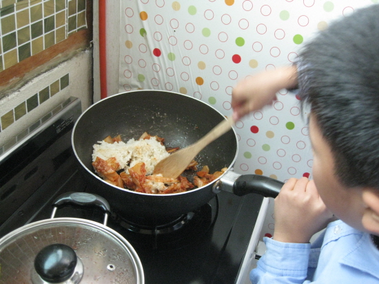  막둥이가 김치에 밥을 넣고 볶고 있습니다. 