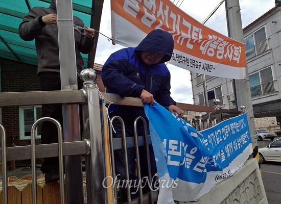 한국고엽제전우회가 25일 오후 1시 '천주교정의구현사제단 시국미사 규탄집회'를 전북 군산 수송동 성당 앞에서 열었다. 참가자들이 사제단 측이 건 플래카드를 찢자 집회 후 성당 관계자들이 다시 플래카드를 걸고 있다.