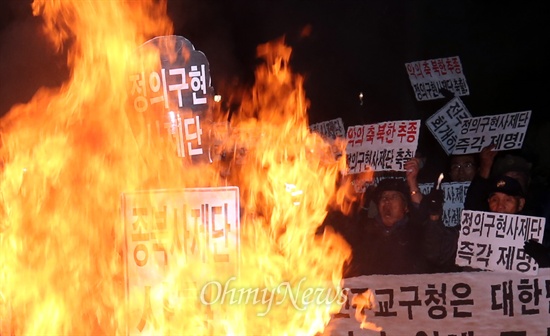 지난 2013년 11월 25일  전북 전주 남노송동 천주교 전주교구청 앞에서 보수단체인 대한민국어버이연합, 대한민국재향경우회, 한국자유총연맹 소속 회원들이 박창신 전주교구 신부의 연평도 포격을 옹호하는 발언과 박근혜 대통령 사퇴를 촉구하는 시국 미사를 규탄하며 화형식을 벌인 모습. 