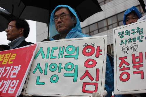  27일 오전 전북 전주시 새누리당 전북도당 앞에서 열린 '시대의 양심 천주교정의구현사제단 시국미사 종북몰이 규탄' 기자회견에 전북시국회의 회원이 사제단을 응원하는 피켓을 들고 참가했다.