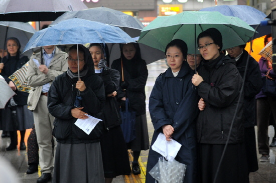 우산을 쓰고 대한문 앞 미사에 참여하고 있는 수녀들의 모습.