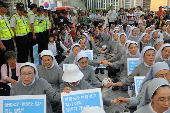 경찰에 둘러싸여 미사에서 기도를 드리고 있는 수녀들의 모습.