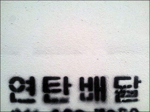 진보길의 한 벽에 써진 연탄배달 문구.