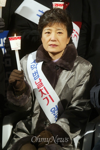 지난 2005년 12월 16일 오후 서울시청 앞 광장에서 열린 사학법 강행처리 무효 대규모 장외집회에서 당시 박근혜 한나라당 대표가 촛불을 들고 있다.