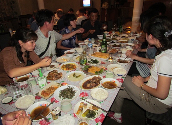 칠보산 여관에서 안내원들과 함께 식사하는 모습