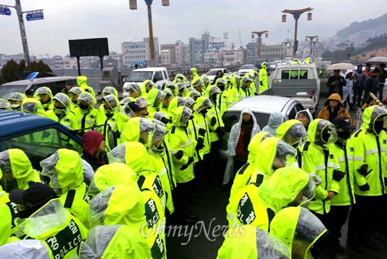  음독 사망한 밀양 송전탑 반대 주민 고 유한숙 할아버지의 시민 분향소가 밀양 영남루 맞은편 밀양교 옆에 설치되었는데, 9일 비가 내리는 속에 주민들이 파렛트를 갖다 놓으려고 했지만 경찰과 밀양시청 공무원들이 막았다. 사진은 현장에 대규모 경찰대원들이 배치되어 있는 모습.