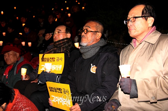  음독 자살한 밀양 송전탑 공사 반대 주민 고 유한숙(74) 할아버지를 기리는 '제1회 추모제'가 11일 저녁 밀양 영남루 계단에서 열렸는데, 장영달 전 민주당 경남도당 위원장(오른쪽)과 천주교 문규현 신부가 나란히 촛불을 들고 앉아 있다.